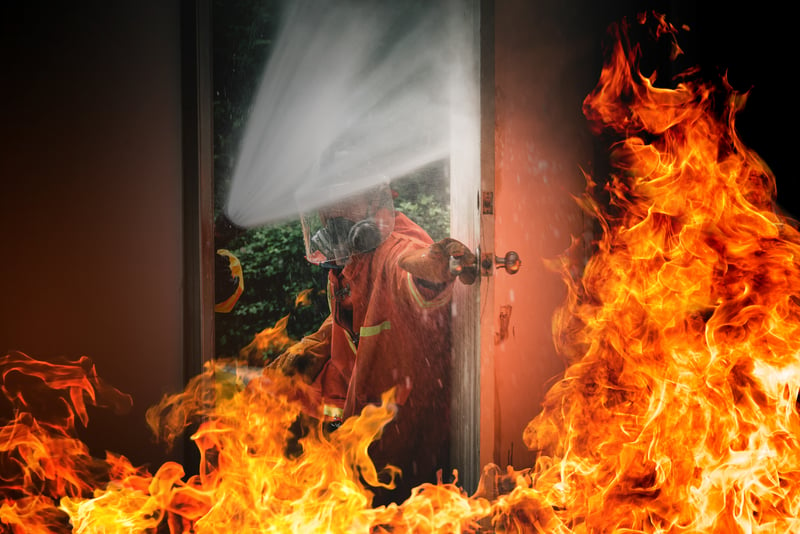 bombero abriendo la puerta de una casa incendiada