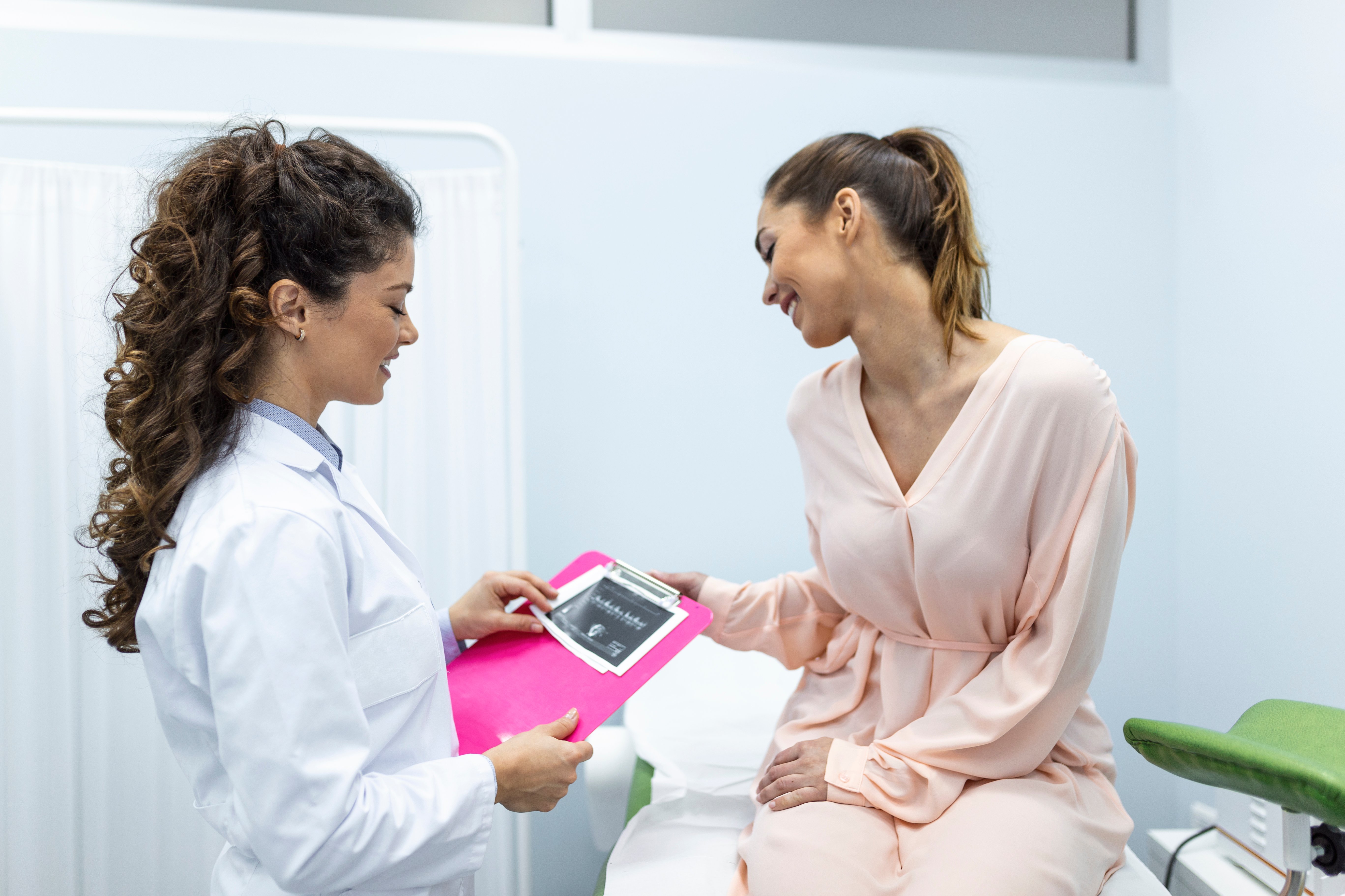 ginecóloga hablando con una paciente joven en un consultorio